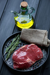 Fresh ribeye steak with seasonings and olive oil, studio shot