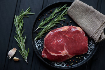 Frying pan with raw fresh ribeye beefsteak, above view, close-up