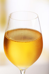 Glass of wine on light blurred background