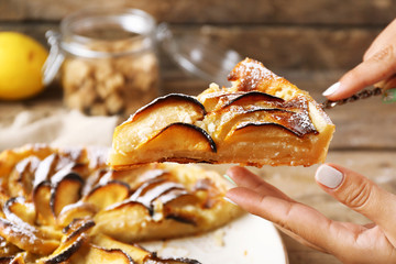 Woman cuts homemade apple cake, close-up