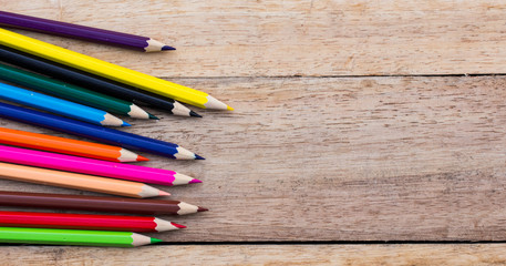 Colorful pencils on wood background