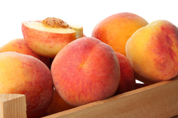 Fresh peaches in wooden crate, closeup