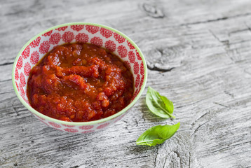 homemade tomato sauce for pasta, in a bowl, on a light wooden background