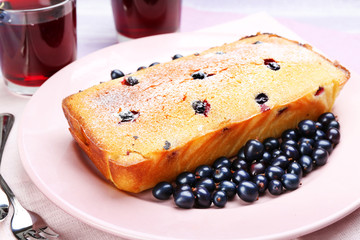 Freshly baked cake with black currants in pink plate, closeup