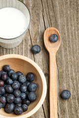 Bowl and spoon with fresh blueberries