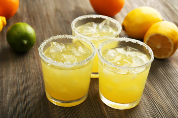 Glasses of lemon juice on wooden table, closeup