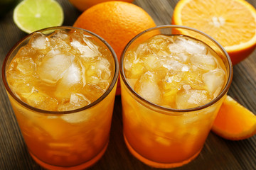 Glasses of orange juice on wooden table, closeup
