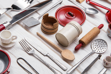 Messer und Gabel mit Geschirr und anderen Küchenutensilien als Dekoration in der Küche im Landhausstil in rot weiß. - obrazy, fototapety, plakaty