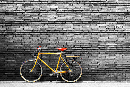 Vintage bicycle on roadside with black and white brick wall background