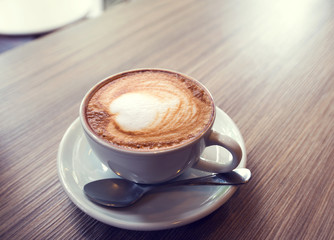 cup of coffee on table in cafe , vintage or retro color effect - shallow depth of field