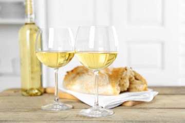 Still life of wine and bread on light background