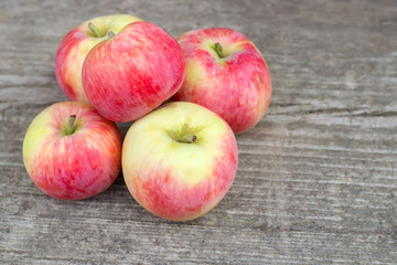 Small group of fresh natural apples on wooden texture