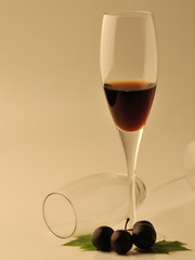 Glass of wine and grapes over white background