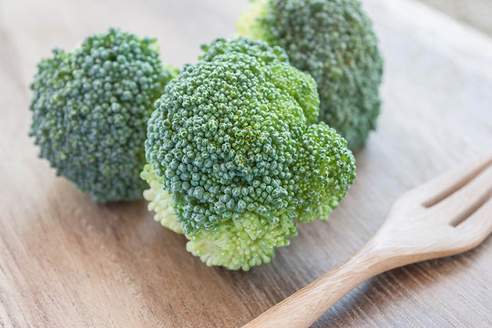 fresh broccoli in wooden bowl on wood table for background