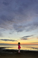 Little cute girl on the sunset  beach