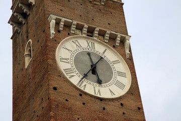 Fototapeta na wymiar Clock on Lamberti Tower on Piazza delle Erbe in Verona, Italy