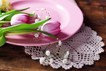 Tableware with flowers on table close up