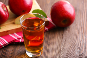 Glass of apple juice and fruits on table close up