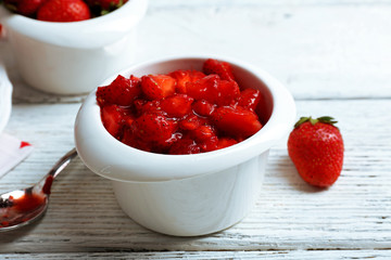 Fresh strawberry in saucer on wooden table, closeup