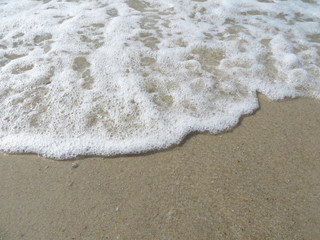 Auslaufende Welle auf Sandstrand