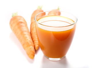 Glass of carrot juice with vegetable slices with vegetables isolated on white