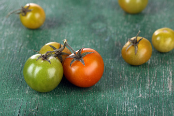 Green tomatoes on wooden table close up