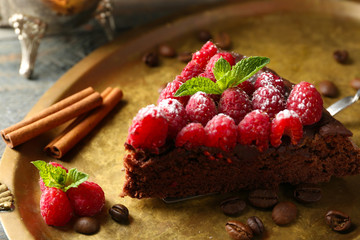 Piece of cake with Chocolate Glaze and raspberries on tray, close-up
