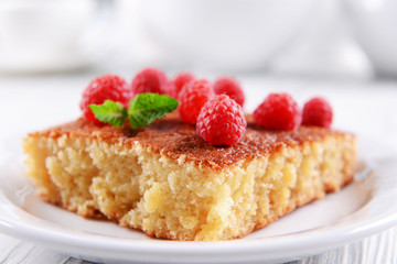 Fresh pie with raspberry in white plate on wooden table, closeup