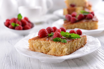Fresh pie with raspberry in saucer on wooden table, closeup