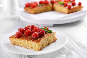 Fresh pie with raspberry in white plate on wooden table, closeup