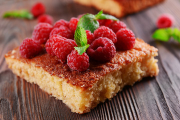 Fresh pie with raspberry on wooden table, closeup