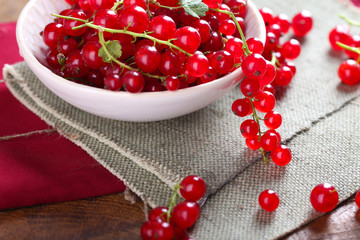 Fresh red currants in bowl on table close up