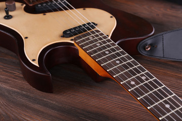 Plakat Electric guitar on wooden table close up