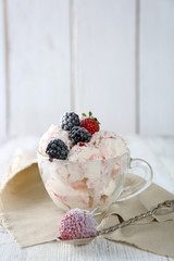Delicious ice cream with fresh frozen berries, on color wooden background