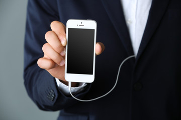 Music smartphone in businessman hand, close-up