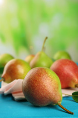 Fresh pears on wooden table on blurred background