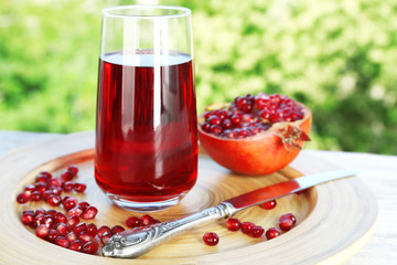Fresh garnet juice with fruit on bright background