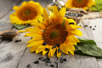 Beautiful bright sunflowers with seeds on wooden table close up