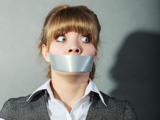 Scared woman with mouth taped shut. Censorship.