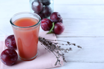 Delicious plum juice with fruits on wooden table close up