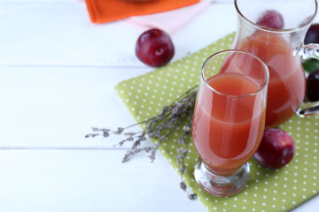 Delicious plum juice with fruits on wooden table close up