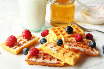 Sweet homemade waffles on tray, on light background