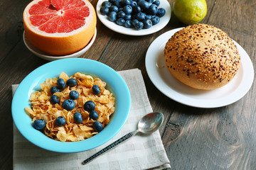 Tasty cornflakes with fruits and berries on table close up