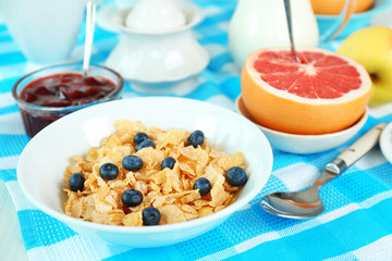 Tasty cornflakes with fruits and berries on table close up
