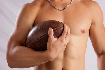 Foto op Plexiglas Shirtless man holding a football © Allen Penton