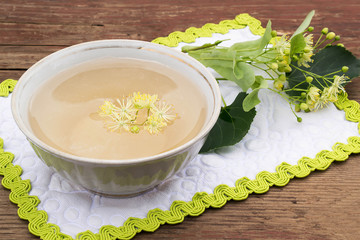Obraz na płótnie Canvas A cup of freshly brewed tea with lime blossom