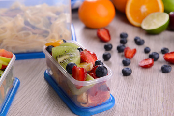 Tasty lunch in plastic containers on wooden table close up
