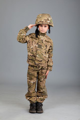 Saluting soldier. Young boy dressed like a soldier