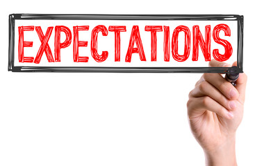 Hand with marker writing the word Expectations