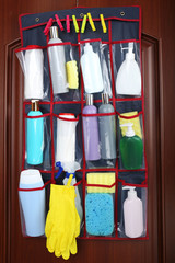 Different detergents in hanging bag wooden door